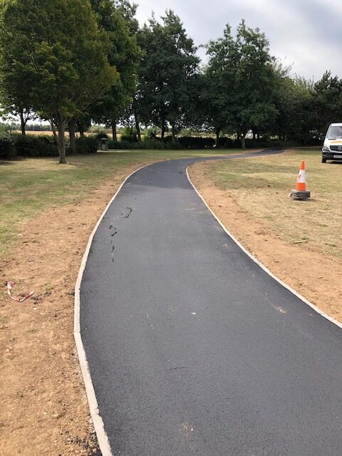 New asphalt footpath installation through park